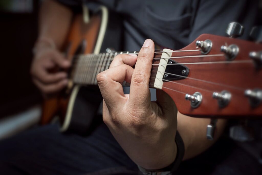 Man playing guitar to help with symptoms of anxiety and depression without the use of medication. Anxiety and depression can be caused by complex trauma, resulting in C-PTSD